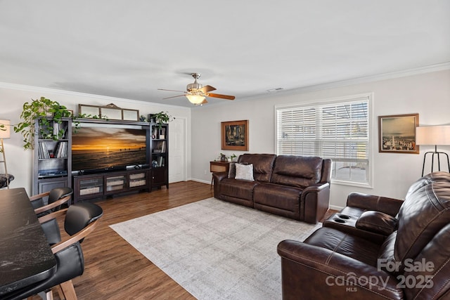 living room featuring crown molding, visible vents, a ceiling fan, wood finished floors, and baseboards