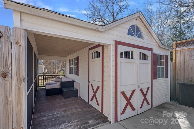 view of outbuilding featuring an outdoor structure and fence