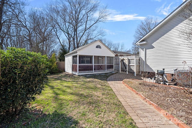 back of property featuring fence and a yard