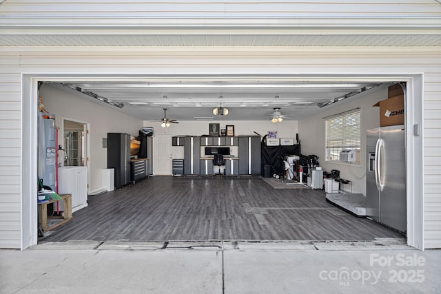 garage featuring ceiling fan and stainless steel refrigerator with ice dispenser