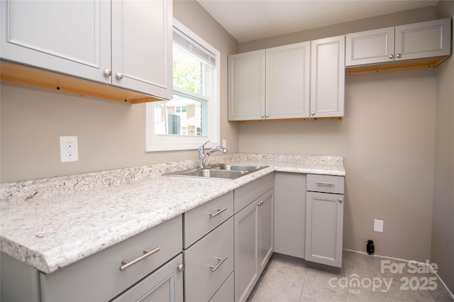 kitchen featuring a sink, light tile patterned floors, and gray cabinets