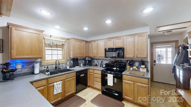 kitchen with decorative backsplash, plenty of natural light, a sink, and black appliances