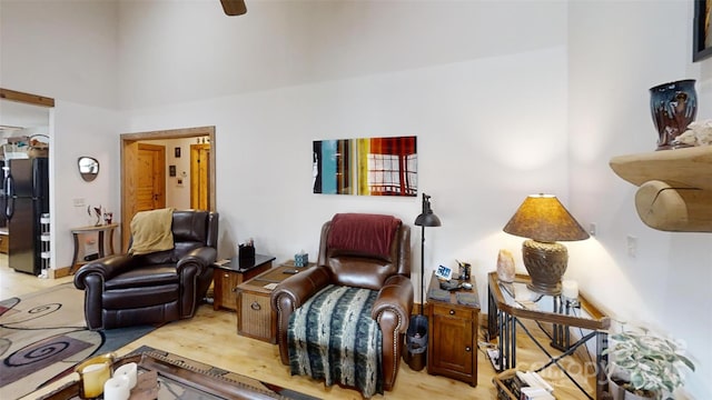 living room featuring a high ceiling and light wood-style floors