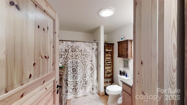 bathroom with toilet, a shower with shower curtain, and vanity