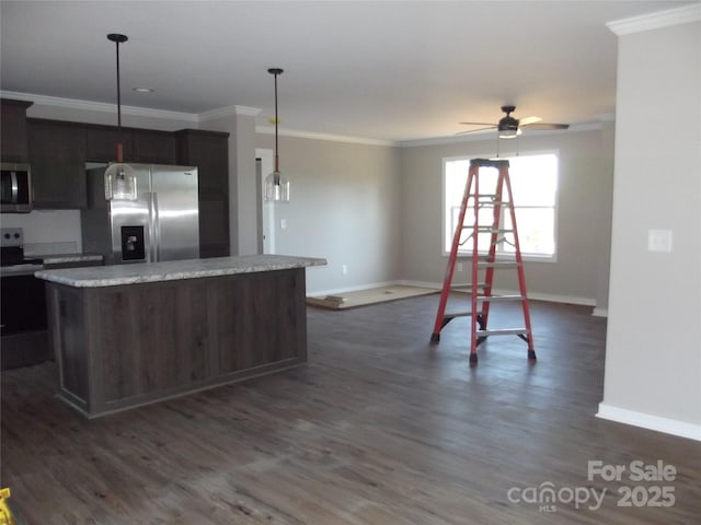 kitchen featuring appliances with stainless steel finishes, dark wood-style flooring, ornamental molding, and a kitchen island