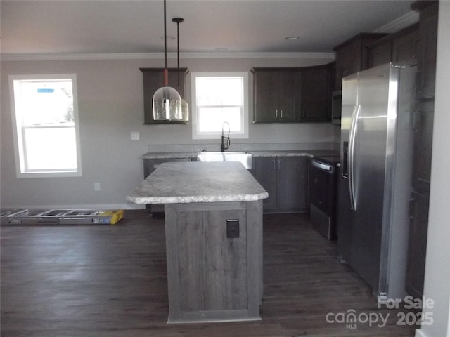 kitchen with dark wood finished floors, stainless steel refrigerator with ice dispenser, ornamental molding, a kitchen island, and a sink