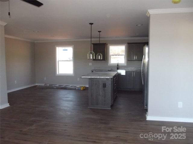 kitchen featuring crown molding, dark wood finished floors, light countertops, freestanding refrigerator, and open floor plan