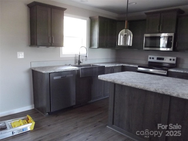 kitchen featuring stainless steel appliances, ornamental molding, a sink, and light countertops