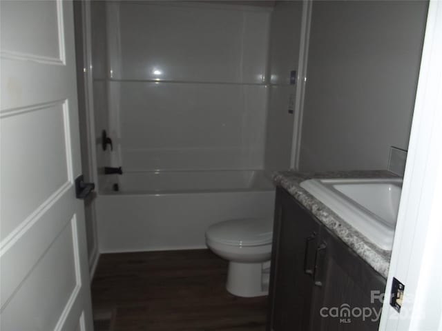 bathroom featuring toilet, shower / bath combination, wood finished floors, and vanity