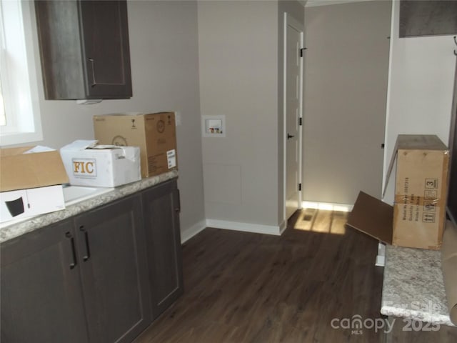 kitchen with dark brown cabinets, dark wood-type flooring, and baseboards