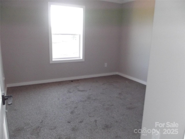 carpeted empty room with baseboards