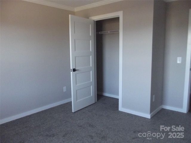 unfurnished bedroom featuring a closet, carpet flooring, crown molding, and baseboards