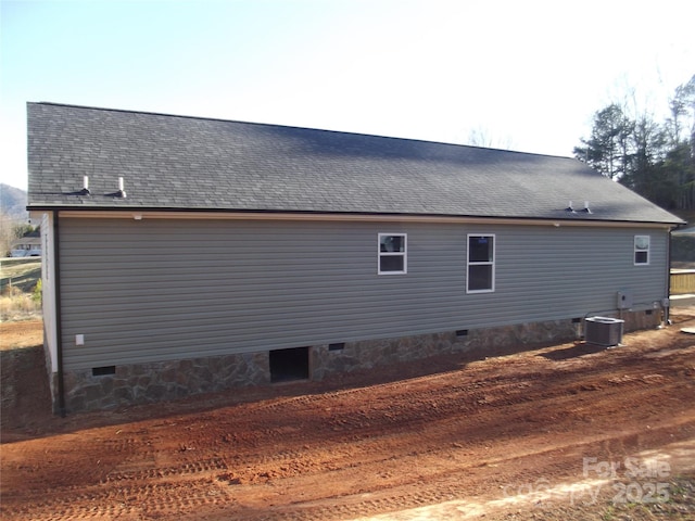 view of property exterior featuring a shingled roof, crawl space, and central air condition unit