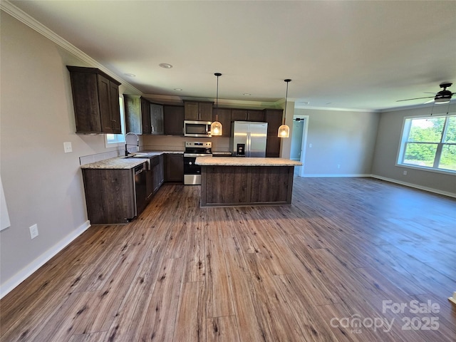784 Severt Cir NE, Lenoir, NC 28645 - kitchen with appliances with stainless steel finishes, open floor plan, a sink, ornamental molding, and dark brown cabinets