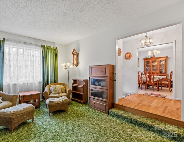 carpeted living area with a textured ceiling and a chandelier