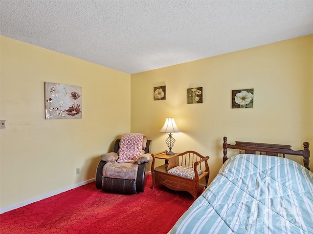 carpeted bedroom featuring baseboards and a textured ceiling