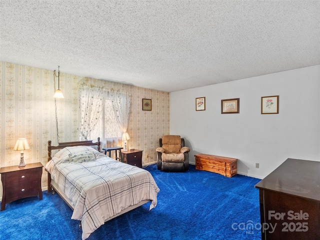 carpeted bedroom with wallpapered walls, a textured ceiling, and baseboards