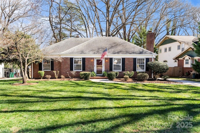 view of front of property with brick siding, a chimney, a front lawn, and fence