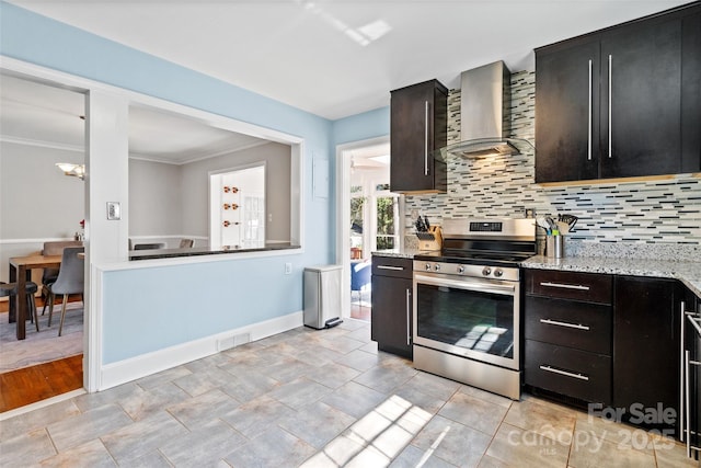 kitchen with wall chimney range hood, decorative backsplash, visible vents, and stainless steel electric stove