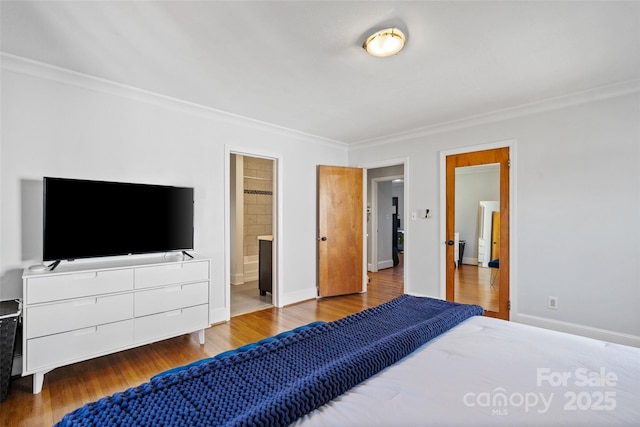 bedroom with crown molding, ensuite bath, wood finished floors, and baseboards