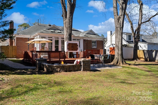 rear view of house featuring a patio, brick siding, fence, a yard, and a wooden deck