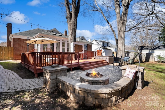 back of house featuring an outdoor fire pit, fence, a chimney, and a wooden deck