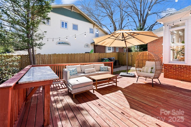 wooden deck featuring an outdoor hangout area and a fenced backyard