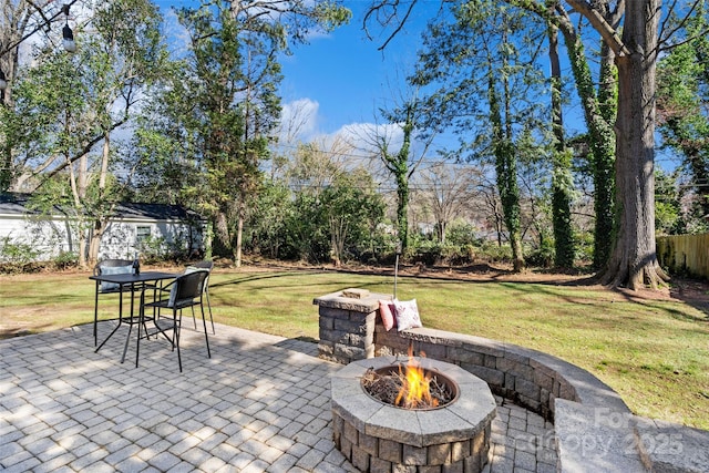 view of patio featuring fence and a fire pit