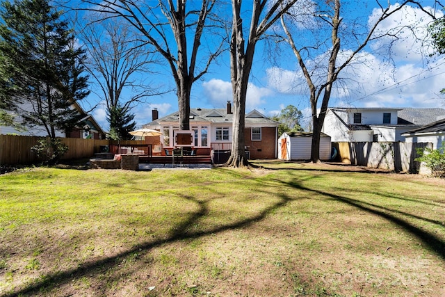 view of yard with a storage shed, an outbuilding, and a fenced backyard