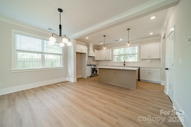 kitchen with custom exhaust hood, stainless steel range, ornamental molding, white cabinetry, and backsplash