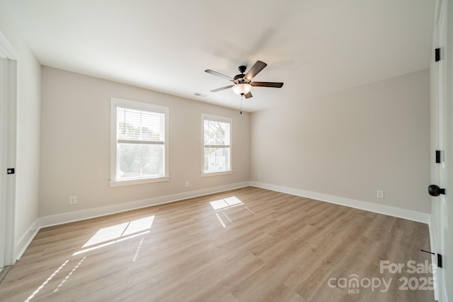 empty room with light wood-style floors, baseboards, visible vents, and ceiling fan