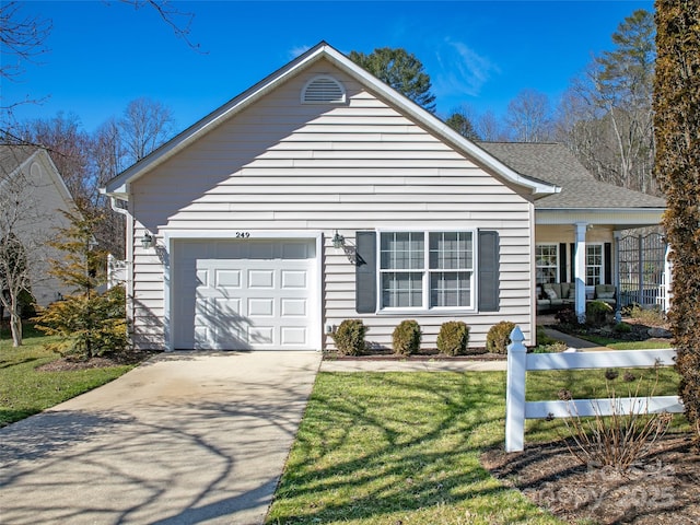 view of front of house with a front lawn, concrete driveway, and an attached garage