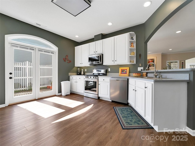 kitchen with stainless steel appliances, white cabinets, a sink, and open shelves