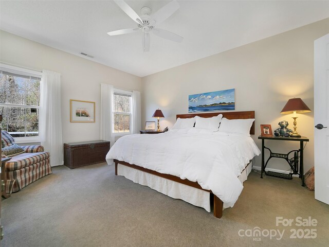 carpeted bedroom with visible vents and a ceiling fan