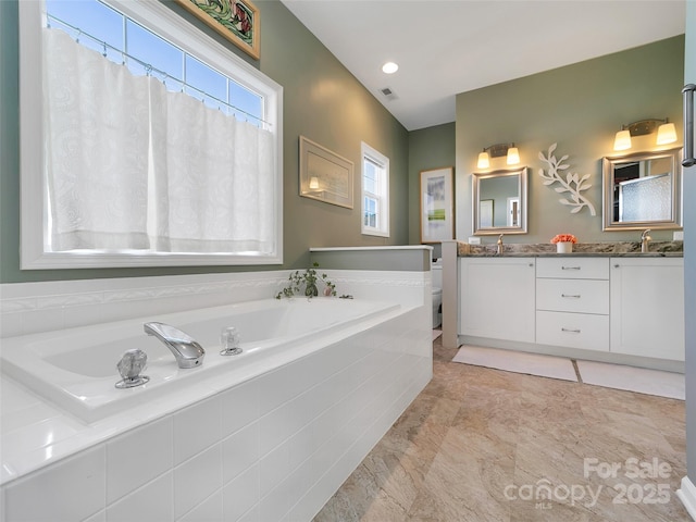 bathroom featuring toilet, visible vents, a sink, and a bath