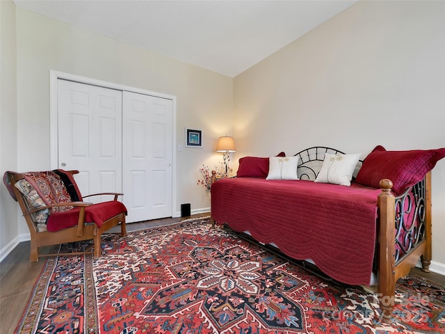 bedroom with a closet, wood finished floors, and baseboards