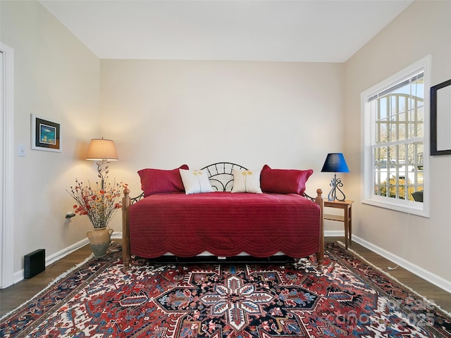 bedroom with baseboards and wood finished floors