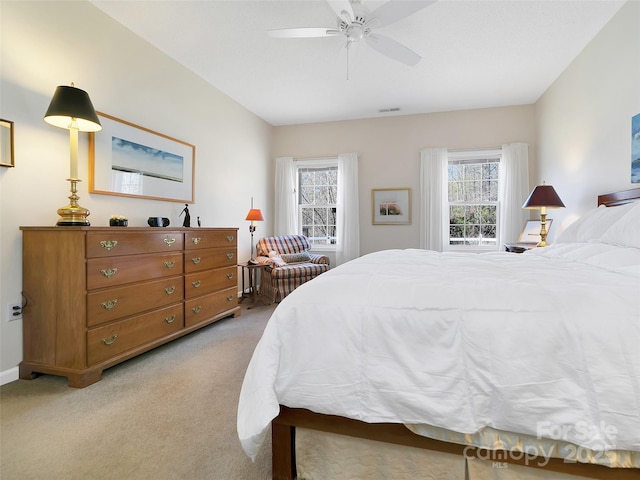 bedroom featuring ceiling fan, visible vents, and light colored carpet