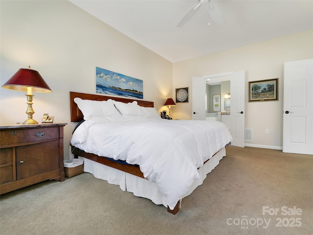 carpeted bedroom featuring a ceiling fan, ensuite bath, visible vents, and baseboards