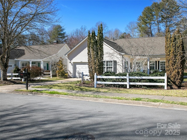 view of front facade featuring a fenced front yard, driveway, and an attached garage