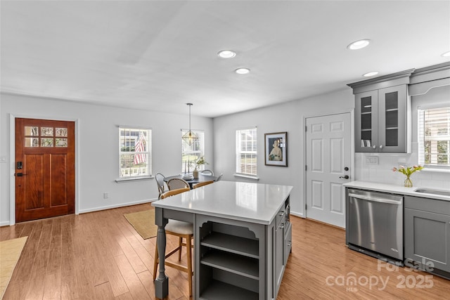 kitchen featuring gray cabinets, light countertops, stainless steel dishwasher, and open shelves