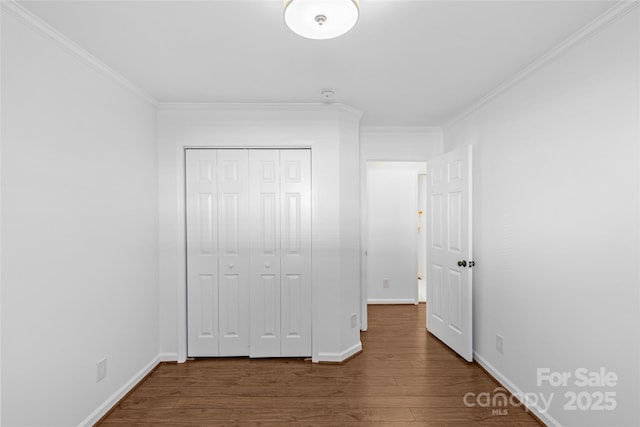 unfurnished bedroom featuring ornamental molding, wood finished floors, and baseboards