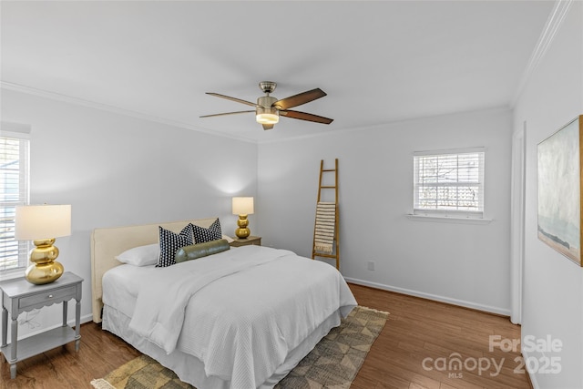 bedroom featuring a ceiling fan, crown molding, baseboards, and wood finished floors