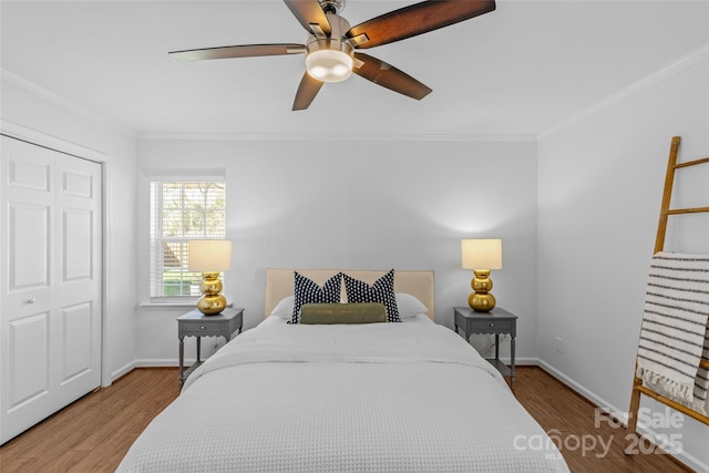 bedroom with baseboards, wood finished floors, and crown molding