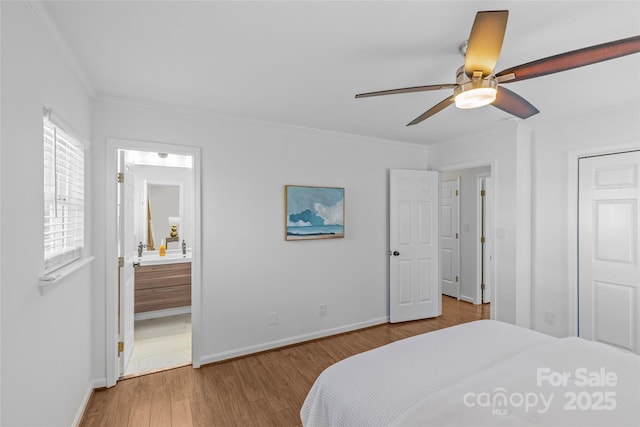 bedroom with crown molding, a ceiling fan, connected bathroom, wood finished floors, and baseboards