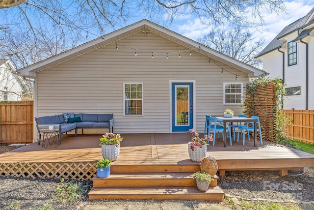 rear view of property with a deck, fence, and an outdoor living space