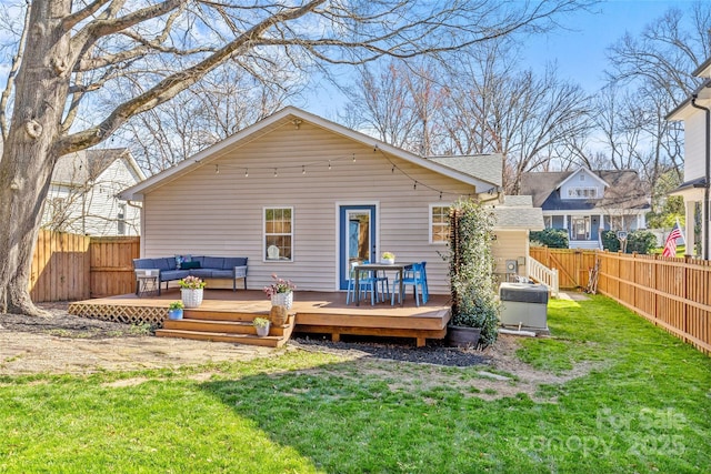 rear view of property with a fenced backyard, a deck, outdoor lounge area, and a yard