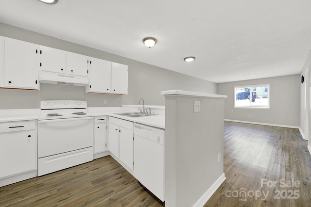 kitchen with white appliances, wood finished floors, light countertops, under cabinet range hood, and a sink