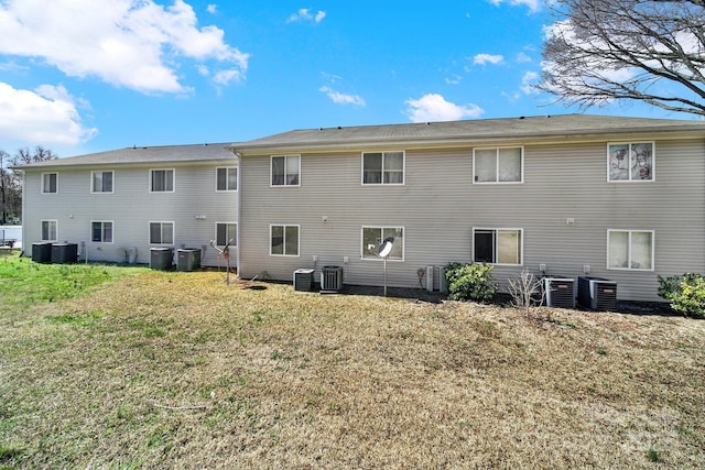 back of house with a lawn and central AC unit