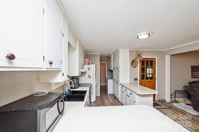 kitchen with a peninsula, dark wood-style floors, white cabinetry, and black microwave